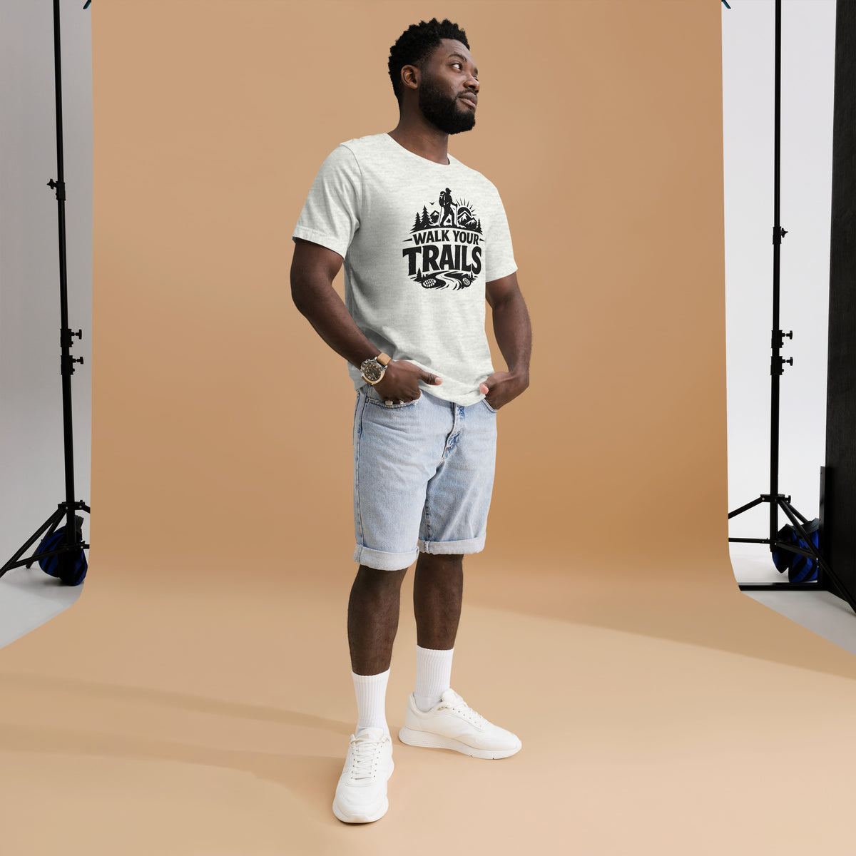 Unisex T-Shirt, Man wearing a white t-shirt with text and light blue shorts standing against a brown backdrop
